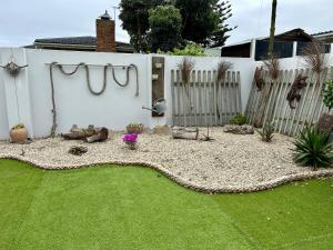 a backyard with a fence and a grass yard at Stoepstories in Yzerfontein +28 photos