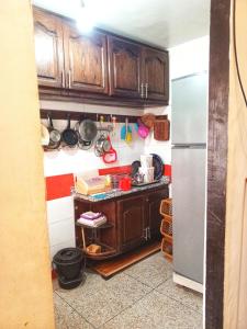 Una cocina con gabinetes de madera y refrigerador. en Appartement confort, en Benguerir