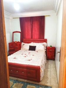Un dormitorio con una cama grande con cabecero rojo. en Appartement confort, en Benguerir