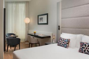 a hotel room with a bed and a desk at NH Collection Palermo Palazzo Sitano in Palermo