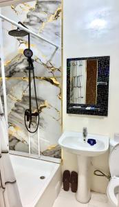 a bathroom with a sink and a tub and a toilet at AsiaHotel in Kokand