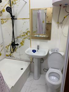 a bathroom with a toilet and a sink at AsiaHotel in Kokand +1 photo