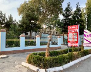 a sign for a hotel in front of a fence at HostelGoldCity in Kokand