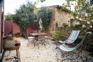een patio met stoelen en een tafel op een binnenplaats bij Gîte Les Mathouans in Latour-de-France