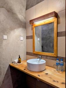 a bathroom with a sink and a mirror on a counter at Mvuli Mountain Lodge Ngorongoro in Karatu