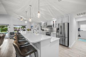 una cucina con un grande bancone bianco e sedie di No Bad Daze a Palma Sola Park