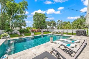 una piscina con sedie a sdraio accanto a una recinzione di No Bad Daze a Palma Sola Park