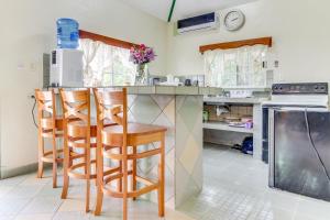 a kitchen with a counter with stools at a bar at La Casita at Midas Belize in Trapiche