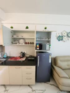 a small kitchen with a refrigerator and a microwave at Infinity Homes in Gurgaon