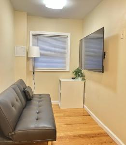 een woonkamer met een bank en een raam bij 2 Bedroom Apartment in Valley Stream