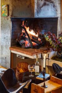 une pièce avec une cheminée et une table avec un verre de vin dans l'établissement Chalet Bachal, à Manigod 24 autres photos
