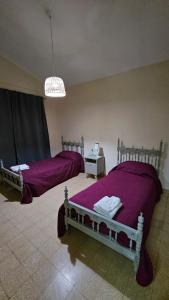 1 Schlafzimmer mit 2 Betten und lila Bettwäsche in der Unterkunft Casa Zárate in Cordoba