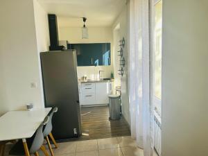 Una pequeña cocina con una mesa y un refrigerador. en Chambre d hotes Marseille Prado, en Marsella