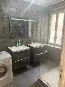 a bathroom with two sinks and a washing machine at Chambre d hotes Marseille Prado in Marseille