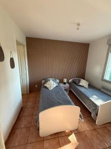 a bedroom with two beds in a room at Appartement cosy-parking et jardin privé in Wattignies