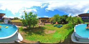 two large swimming pools in a yard with a house at The Friends Hostel & Sauna in Kutaisi
