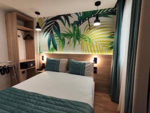 a bedroom with a bed with a painting on the wall at Atelier Montparnasse Hôtel in Paris
