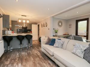 a living room with a couch and a kitchen at Costapacket in Troutbeck Bridge
