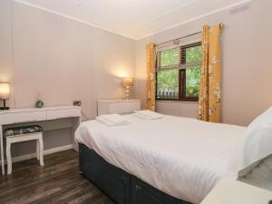 a bedroom with a large white bed and a fireplace at Costapacket in Troutbeck Bridge