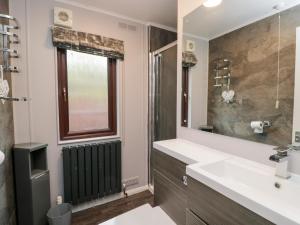 a bathroom with a sink and a large mirror at Costapacket in Troutbeck Bridge +21 photos
