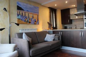 a living room with a couch and a kitchen at Apartamentos Zarautz Playa4, con piscina y garaje in Zarautz