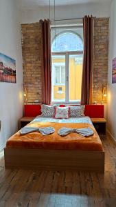 une chambre avec un grand lit avec une grande fenêtre dans l'établissement GoodMo Budapest Smart Rooms, à Budapest