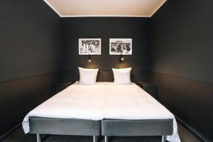 a bed in a room with two pictures on the wall at Hotel Maritime in Copenhagen +67 photos