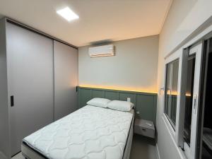 une petite chambre avec un lit et une fenêtre dans l'établissement Smart Home em Capão da Canoa, à Capão da Canoa 9 autres photos