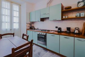 a kitchen with blue cabinets and a table with a tableablish at Appartamento in centro storico La Corte in Domodossola