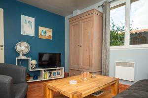 a living room with a coffee table and a tv at Gîte Les Mathouans in Latour-de-France