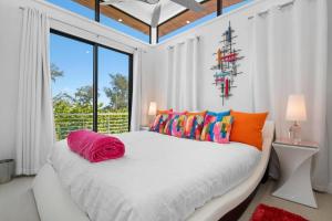 a bedroom with a white bed with colorful pillows at Anna Maria Wave in Ilexhurst +66 photos