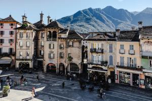 a group of buildings with mountains in the background at Appartamento in centro storico La Corte in Domodossola