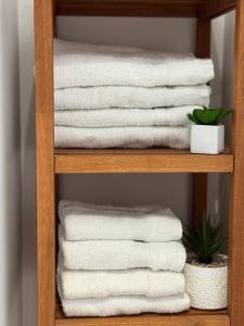 a stack of towels on a wooden shelf at Bel appartement en rez-de-jardin à 100m des plages in Saint-Nazaire