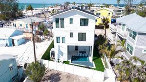 une vue aérienne d'une maison blanche avec piscine dans l'établissement Sunset Serenade, à Bradenton Beach