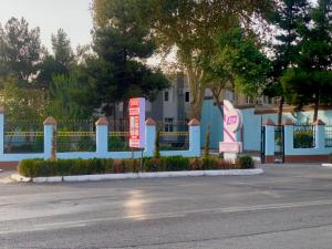 a blue building with signs on the side of a street at AsiaHotel in Kokand