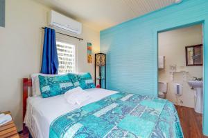 Dormitorio azul con cama y lavamanos en DV #1 at DV Cabanas - Gold Standard Certified, en Caye Caulker