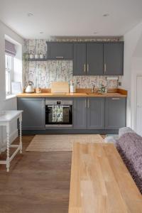 a kitchen with dark blue cabinets and a table at Broom House at Egton Bridge in Egton