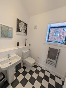 フォーディングブリッジにあるFordingbridge New Forest Town Apartmentの洗面台、トイレ、窓のあるバスルーム