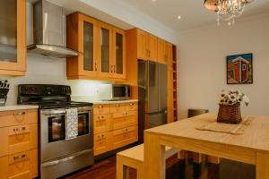a kitchen with wooden cabinets and a wooden table at Modern Townhouse in the Heart of Downtown in St. John's
