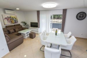 a living room with a couch and a table and chairs at Apartments Sana 2 in Vir
