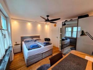 a bedroom with a bed and a ceiling fan at Design-Wohnung im Zentrum mit Balkon und Parkplatz in Offenbach