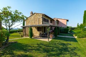 an old stone house in a garden with a lawn at Villa i Colli in Montaione
