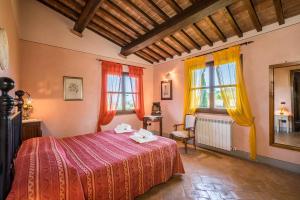 a bedroom with a bed and two windows at Villa i Colli in Montaione