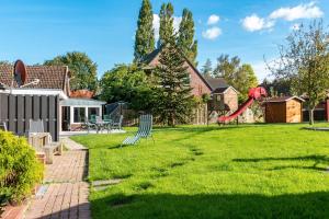 a yard with a slide and a playground at Nordsee Ferienwohnung Wattwurm in Thunum