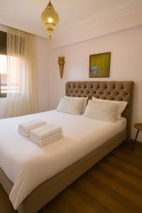 a bedroom with a large white bed with white pillows at Sabor Apartment Anas Majorelle in Marrakech