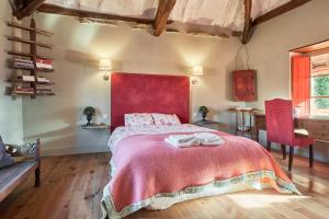 a bedroom with a large bed with a red headboard at La Madrigata al completo in Revilla de Cepeda