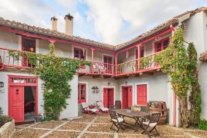 a house with red doors and a patio with a table at La Madrigata al completo in Revilla de Cepeda