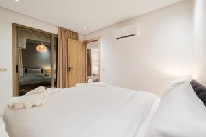 a white bed in a room with a bedroom at NEW Apartment Central 1BR-Queensize, AC&Terrace in Marrakech