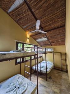 a room with three bunk beds and a ceiling at Fm Luxury villa Arquitectura tipo yakarta con Playa artificial y Cinema al aire libre in Melgar