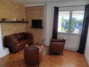 a living room with a couch and chairs and a television at Aubocoteau in Saint-Paterne-Racan